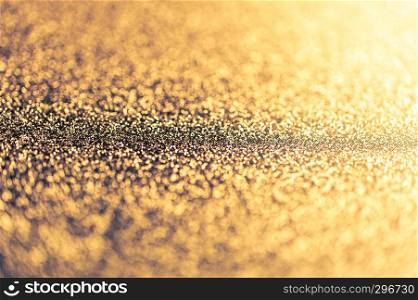 Abstract shiny golden background with bokeh and defocused lights. Glitter glowing texture pattern. Selective focus. Shallow depth of field. Christmas theme.. Abstract shiny golden background with bokeh and defocused lights. Glitter glowing texture pattern.
