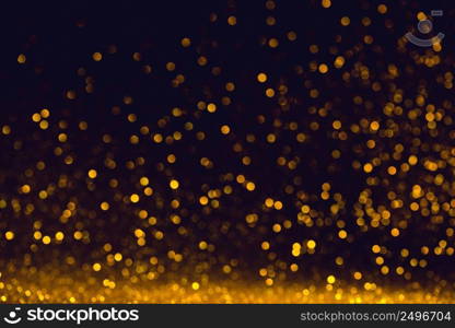 Abstract small golden bokeh lights on dark background