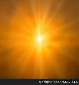 Abstract sunset- shining orange sun with sunbeams over sky background