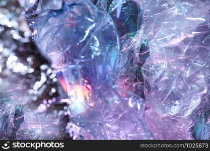 Abstract trendy holographic background in the style of the 80-90s. Real texture of crumpled cellophane film in bright acid colors. Synthwave Vaporwave webpunk Massurrealism aesthetics.. Holographic background in the style of the 80-90s. Real texture of cellophane film in bright acid colors.