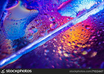 Abstract trendy holographic background in the style of the 80-90s. Real texture of broken glass or ice and water drops in bright acid colors. Synthwave Vaporwave webpunk Massurrealism aesthetics.. Background in the style of the 80-90s. Real texture of broken glass or ice and drops in bright acid colors.