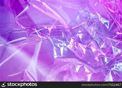 Abstract trendy holographic background in the style of the 80-90s. Real texture of crumpled cellophane film in bright acid colors. Synthwave Vaporwave webpunk Massurrealism aesthetics.. Holographic background in the style of the 80-90s. Real texture of cellophane film in bright acid colors.