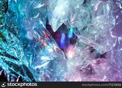 Abstract trendy holographic background in the style of the 80-90s. Real texture of crumpled cellophane film in bright acid colors. Synthwave Vaporwave webpunk Massurrealism aesthetics.. Holographic background in the style of the 80-90s. Real texture of cellophane film in bright acid colors.