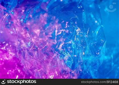 Abstract trendy holographic background in the style of the 80-90s. Real texture of crumpled cellophane film in bright acid colors. Synthwave Vaporwave webpunk Massurrealism aesthetics.. Holographic background in the style of the 80-90s. Real texture of cellophane film in bright acid colors.
