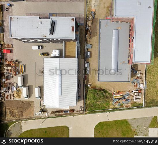 Abstract vertical aerial view of two newly built industrial halls in an industrial area, made with drone