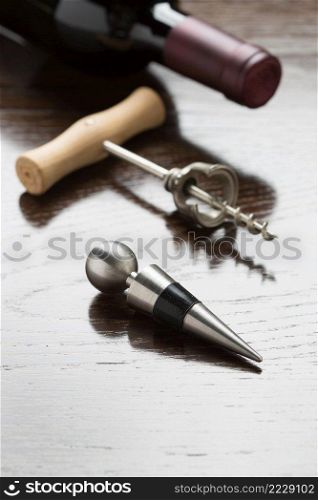 Abstract Wine Bottle, Corkscrew and Stopper Laying on a Reflective Wood Surface.