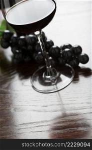 Abstract Wine Glass and Grapes on a Reflective Wood Surface.