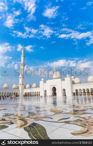 ABU DHABI, UAE - JUNE 11: The Sheikh Zayed Grand Mosque, muslims and tourists on June 11, 2013 in Abu Dhabi, UAE. It is the largest mosque in UAE and eighth largest mosque in world