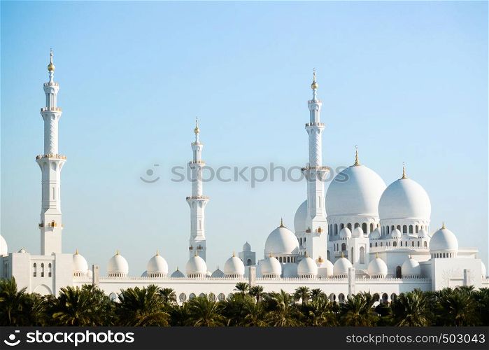 Abu Dhabi, UAE - Sheikh Zayed Mosque, Grand white marble mosque of Abu Dhabi with many dome architecture and blue sky background.