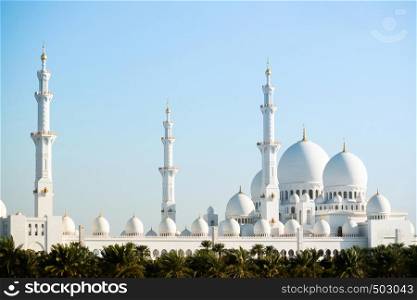 Abu Dhabi, UAE - Sheikh Zayed Mosque, Grand white marble mosque of Abu Dhabi with many dome architecture and blue sky background.
