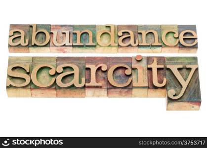 abundance and scarcity - isolated words in n letterpress wood type blocks stained by color inks