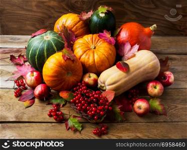 Abundant harvest concept with pumpkins, apples and berries . Abundant harvest concept with pumpkins, apples and berries. Thanksgiving background with seasonal vegetables and fruits. Fall background.