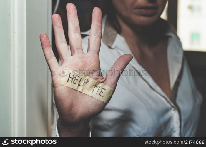 Abused woman&rsquo;s hand with writing help me