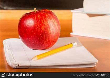 Academic education traditional student&acute;s desk apple, pencil and notepad