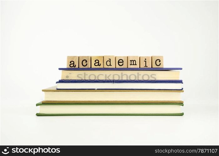 academic word on wood stamps stack on books, business and education concept