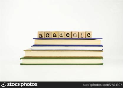 academic word on wood stamps stack on books, business and education concept