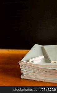 Academical notepads and chalks on wooden desk traditional decor