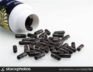 Acai Berry Capsules Spilling Out Of A Plastic Bottle, On To A White Background