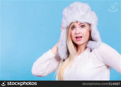 Accessories and clothes for cold days, fashion concept. Blonde woman in winter warm furry hat in russian style.. Blonde woman in winter warm furry hat