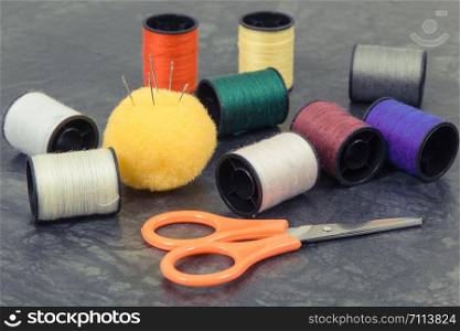 Accessories and tools for using in sewing and needlework. Spools of thread, needle, scissors. Accessories and tools for using in sewing. Spools of thread, needle, scissors