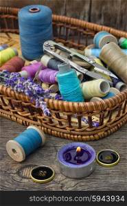 Accessories for sewing. Basket with spools of thread and buttons and fresh lavender.