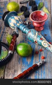 Accessories for Shisha. Dismantled parts of hookah on a wooden background with lime fruit