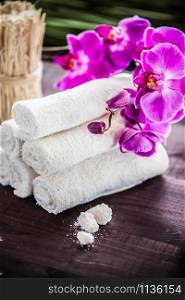 Accessories for spa. White towels, orchid and stones for spa. White towels, orchid and stones for spa