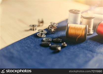 Accessories for tailoring on fabric and wooden top.