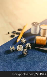 Accessories for tailoring on fabric and wooden top.