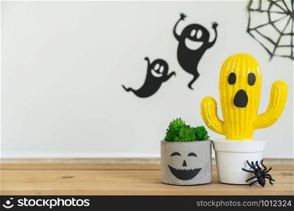 Accessories of decorations Happy Halloween day background concept.Jack O Lanterns cactus with ghost object to party season with spider & web on modern rustic brown & white stone backdrop.copy space.