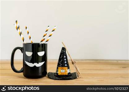 Accessories of decorations Happy Halloween day background concept.Jack O Lanterns cup of drink with Witch&rsquo;s broom of object to party season on modern rustic brown & white stone backdrop.copy space.