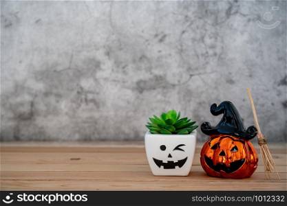 Accessories of decorations Happy Halloween day background concept.Jack O Lanterns cactus with spooky pumpkins object to party season with witch&rsquo;s broom on modern rustic brown & white stone backdrop.