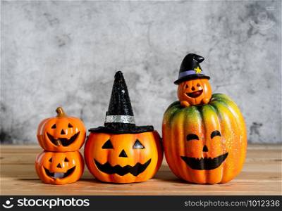 Accessories of decorations Happy Halloween day background concept.Variety of Jack O Lanterns pumpkins object to party season with spider on modern rustic brown & white stone backdrop.copy space.