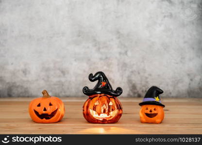 Accessories of decorations Happy Halloween day background concept.Variety of Jack O Lanterns pumpkins object candle to party season on modern rustic brown wooden & black stone backdrop.copy space.