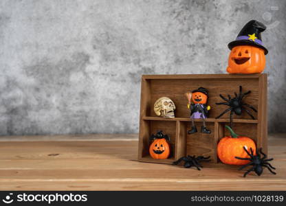 Accessories of decorations Happy Halloween day background concept.Jack O lantern pumpkin objects on shelf wood to party season with spider and skeleton on brown wooden & stone backdrop.copy space.