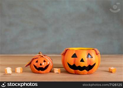 Accessories of decorations Happy Halloween day background concept.Couple jack O Lanterns with spooky pumpkins object to party season with sweet candy on modern brown & white stone backdrop.copy space