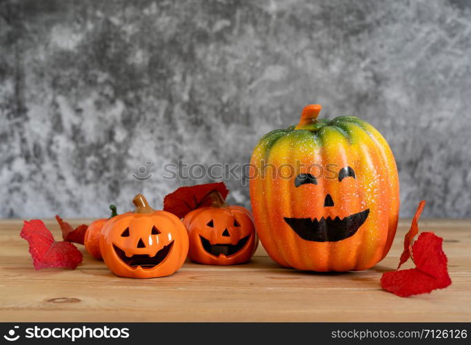 Accessories of decorations Happy Halloween day background concept.Variety of Jack O Lanterns pumpkins object to party season with autumn leaves on modern rustic brown & white stone backdrop.copy space