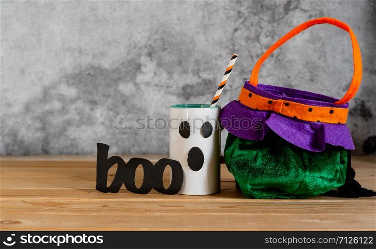 Accessories of decorations Happy Halloween sale day background concept.Cup of drink with pumpkin bag object to party season with spider on brown & white backdrop at home office desk studio.copy space