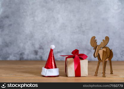 Accessories of Merry Christmas decorations & Happy new year ornaments concept.Gift box with santa claus hat with reindeer object to party season on modern rustic brown & grey stone backdrop.