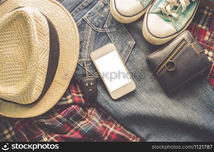 Accessory jeans smart devices earphones hat glasses on a wooden floor.