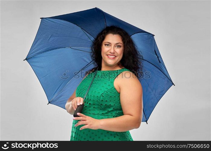 accessory, rainy weather and season concept - happy woman in green dress with blue umbrella over grey background. happy woman in green dress with blue umbrella