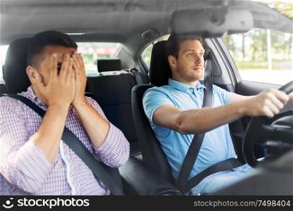 accident, emotion and fear concept - scared car driving school instructor and young male driver. car driving school instructor and male driver