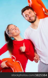 Accident prevention and water rescue. Man and woman lifeguard couple holding buoy lifesaver equipment giving thumb ub hand sign gesture on blue