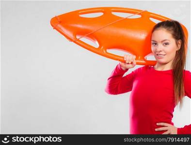 Accident prevention and water rescue. Young woman female lifeguard on duty holding float lifesaver equipment on gray. Copy space