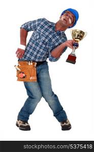 Accident prone construction worker holding a trophy