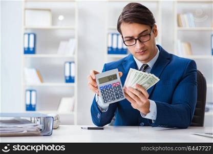 Accountant calculating dollars with calculator in office