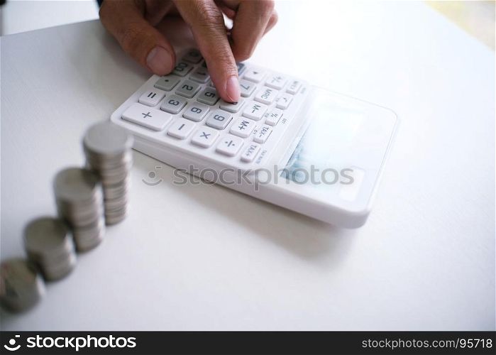 Accountant verify the business and saving money stacking gold coins with calculator. Accountancy Concept.