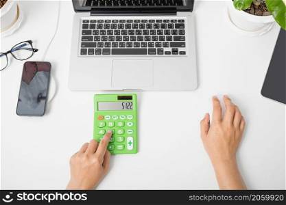 Accountant working and analyzing financial calculating with calculator and laptop computer income-expenditure at office desktop, Business financial and tax systems concept