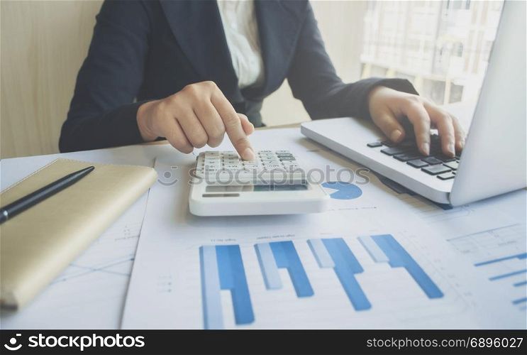 accountant working on report data documents with calculator