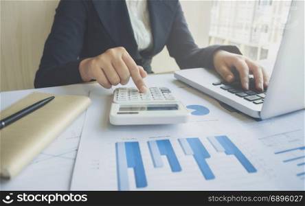 accountant working on report data documents with calculator